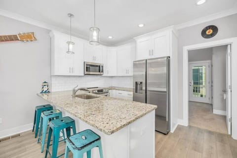 Fully stocked kitchen with pots and pans. Fridge has water/ice dispenser