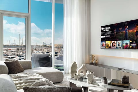 Stunning open plan lounge with 65 inch Smart TV,  floor to ceiling windows, balcony and incredible sea view