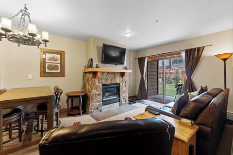 Unwind in your cozy living space with leather seating, stone fireplace, and dining area perfect for memorable evenings together.