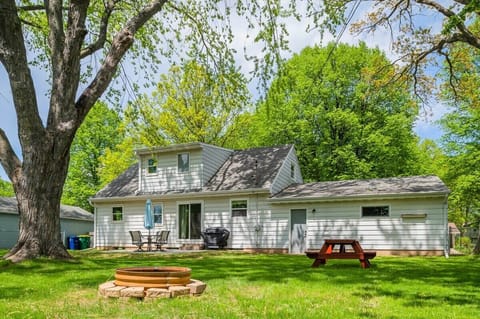 The backyard offers a spacious patio with comfortable furniture, a cozy fire pit, and a picnic table, providing the perfect setting for outdoor relaxation and entertainment.
