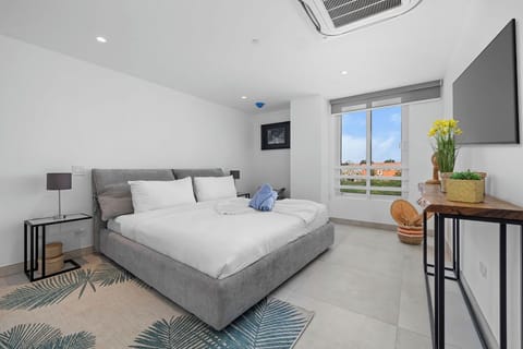 Sink into crisp white linens and unwind in your private retreat, where a plush bed and cheerful touches set the tone for restful nights.
