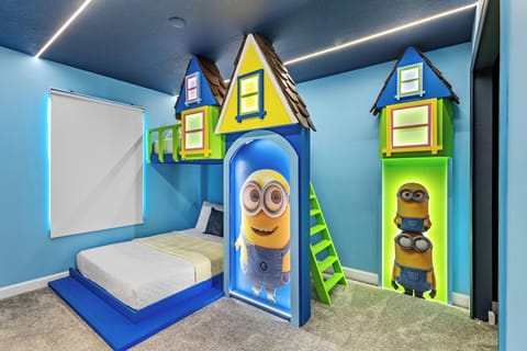 This vibrant children’s bedroom boasts whimsical Minion-themed decor and bright blue walls, featuring playful house-shaped beds. With plenty of natural light, it creates a fun and energetic atmosphere for your little ones.