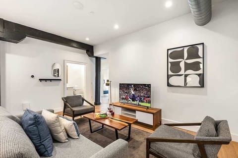 Open-concept living area featuring cozy furnishings, smart TV, and a sleeper sofa.