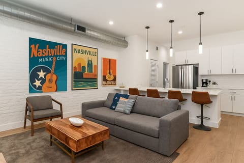 Unit 1: Open-concept living area featuring cozy furnishings, smart TV, and a sleeper sofa.