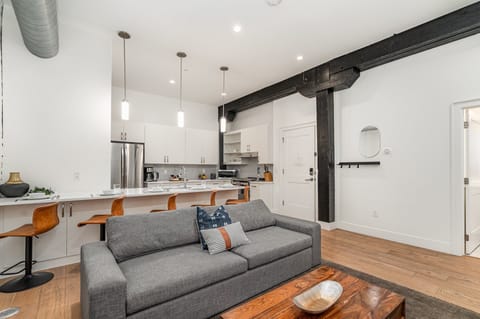 Unit 1: Open-concept living area featuring cozy furnishings, smart TV, and a sleeper sofa.