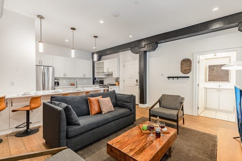 Unit 1: Open-concept living area featuring cozy furnishings, smart TV, and a sleeper sofa.