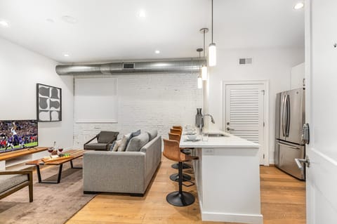 Unit 1: Open-concept living area featuring cozy furnishings, smart TV, and a sleeper sofa.