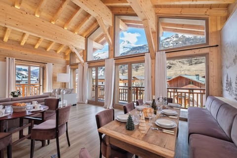 Bright living room with panoramic mountain views and magnificent cathedral bay windows.