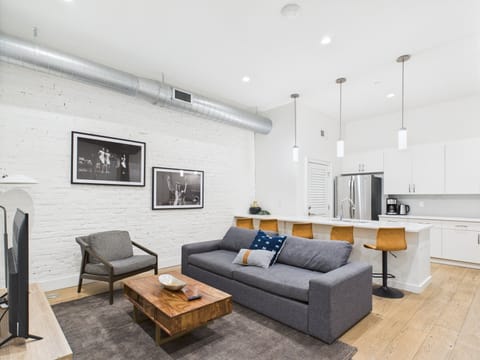 Unit 1: Open-concept living area featuring cozy furnishings, smart TV, and a sleeper sofa.