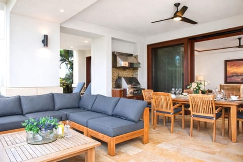 A spacious sectional and wood beam ceilings anchor your living area, flowing seamlessly to the lanai through wide sliding glass doors. MON-2204