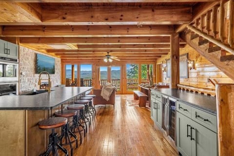 Luxe Open-Concept Living – Spacious living area with floor-to-ceiling windows, cedar plank ceilings, and an electric fireplace.