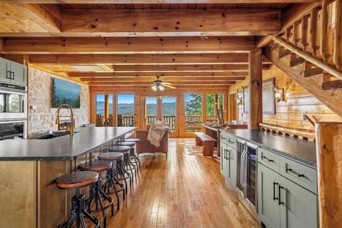 Luxe Open-Concept Living – Spacious living area with floor-to-ceiling windows, cedar plank ceilings, and an electric fireplace.