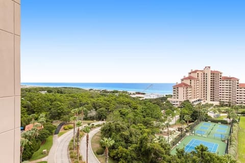 Panoramic view showcasing tennis courts, lush green spaces, and distant ocean waters from this elevated coastal location.