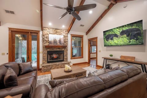 Living room with 75 inch television. Leather sofas with queen size pullout.