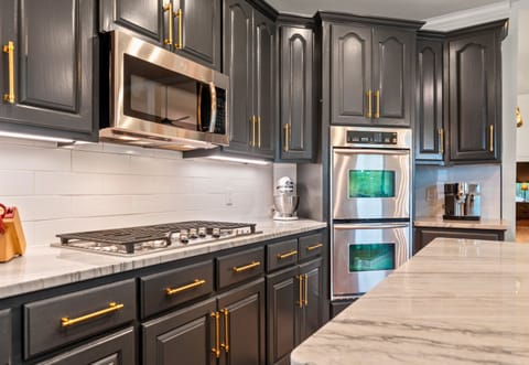Double ovens, a six-burner gas cooktop, and marble counters make this space a dream for anyone who loves to cook or entertain in style.