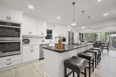 Kitchen | Modern White Cabinetry, Large Island with Seating, and Stainless Steel Appliances