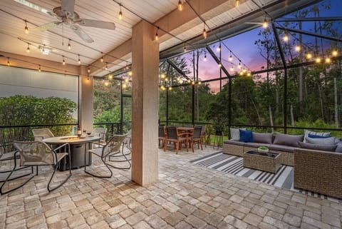 An outdoor oasis awaits you in the screened in lanai with string lights.