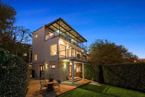 Evening exterior of the home highlighting architectural design and landscaped garden.