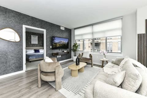 Chic and bright living room with cozy couch, flatscreen Tv and dedicated work station