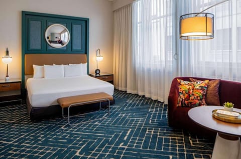 Spacious bedroom with king bed and colorful lounge area.