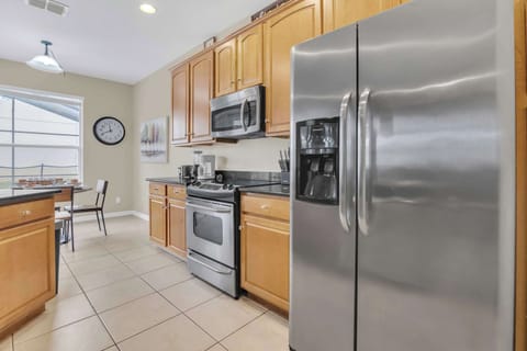 Modern stainless steel elegance meets warm wood cabinetry in this sun-drenched culinary haven.