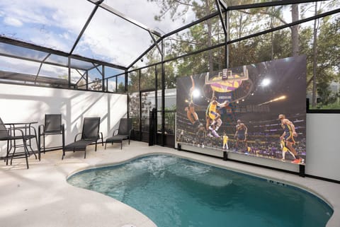 Relax by the sparkling pool in a sleek setting, perfect for sunny days. Enjoy the cozy seating area to unwind, and take advantage of the large screen for memorable evenings filled with entertainment.