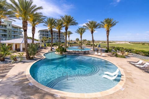 Resort-style infinity pool with palm trees and ocean views in Pointe West Galveston beachfront community