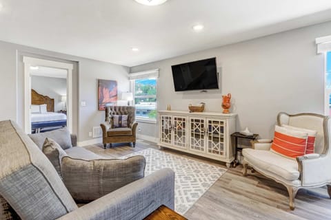 Spacious open-concept living area with cozy seating, a Smart TV, and large windows framing mountain views








