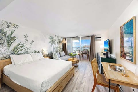 Beautiful studio with queen-size bed perfect for relaxing, designated working space with table and chair, futon sofa, window AC, and a 54" Smart TV.