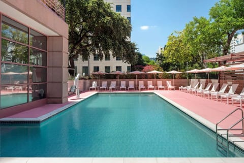 Outdoor pool with pink lounge chairs and umbrellas
