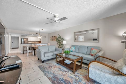 Open-concept living space w/ plush sofas, coastal accents, and bright natural light throughout.