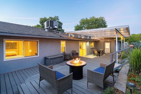 Covered deck with a fire pit and outdoor dining