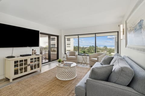 Serene Living Area Featuring Plush Couch and Chairs, Flat Screen Smart TV, and Comfortable Modern Decor