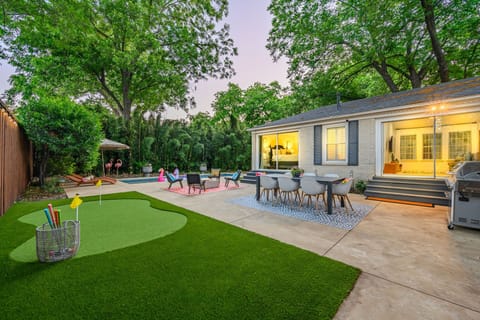 Backyard paradise awaits you! Large patio with dining table, BBQ grill, fire pit, putting green, and pool!