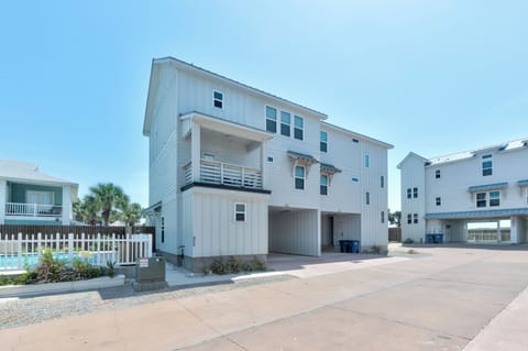 Modern beach house featuring elevated design with ground-floor parking and covered outdoor spaces in a coastal residential community.