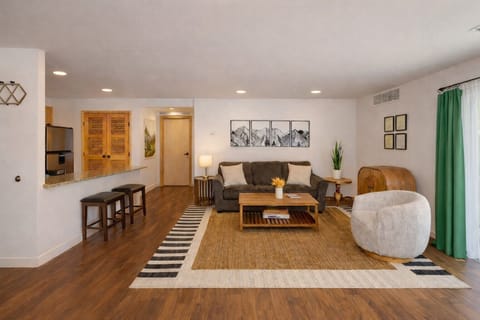 Unwind in this stylish living room with warm wood floors, cozy seating, and modern touches that make relaxing feel effortless.