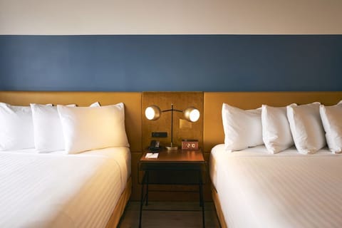 Drift off surrounded by crisp linens and calming designer tones.