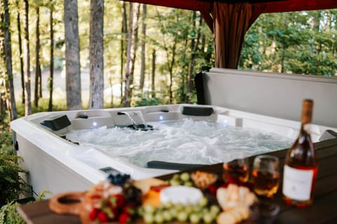 Private lake-view hot tub with a table and chairs for cozy evenings