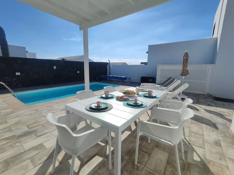 Comedor al aire libre con porche techado