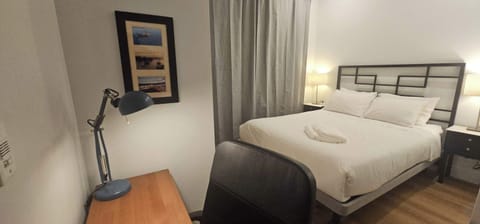 Stylish bedroom with soft lights, workspace, and cozy queen bed