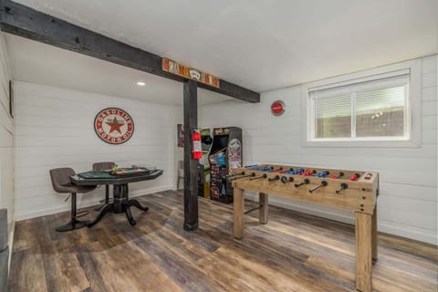 Game room with poker table, arcade machines, and foosball