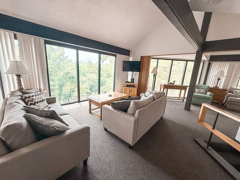 Unit 52s living room offers comfort and style with a wooded view just outside your window.