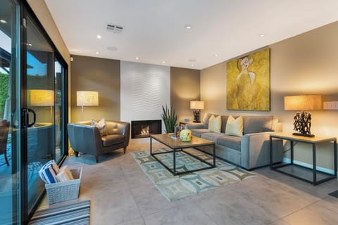 Open living room with fireplace and patio access in Palm Springs retreat