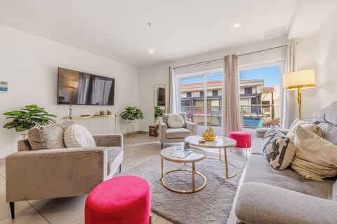 Sink into plush sofas and let sunlight spill through open glass doors. Your living room flows seamlessly to the pool area, creating an airy oasis for gathering and unwinding.