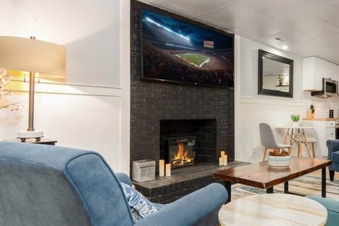 Cozy basement living room with a Smart TV for movie nights and an air hockey table for a little friendly competition. The perfect space to unwind or play.