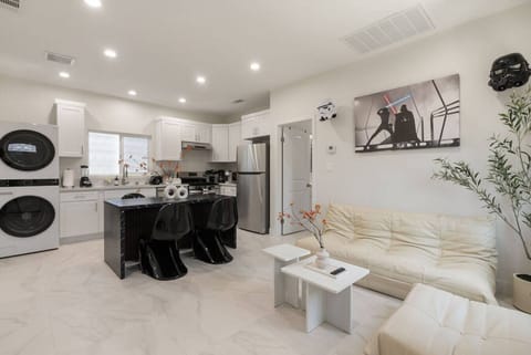 Sleek modern retreat ✨ with a chic black-and-white kitchen 🍽️, cozy cream sofa 🛋️, and stylish sci-fi accents 🚀
