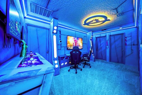 Experience the thrill in our vibrant gaming room, where electric blue walls energize the atmosphere. Enjoy hours of fun with our ergonomic chairs, sleek setup, and immersive ambient lighting designed just for you.