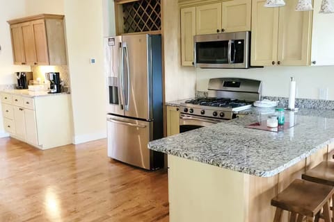 Main house kitchen with gas stove and breakfast bar.