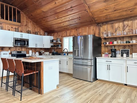 Fully equipped kitchen with island, stove, microwave & full fridge.