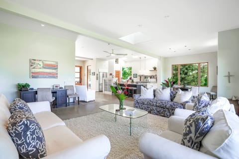 Living room seating with open kitchen view and work desk and extra seating Too.